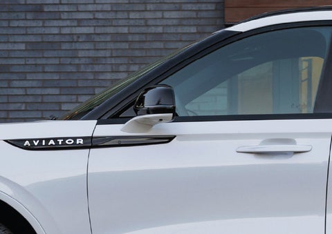 The driver’s side door and fender badging of a white 2026 Lincoln Aviator® SUV are showcased. | Deacon Jones Lincoln in Goldsboro NC