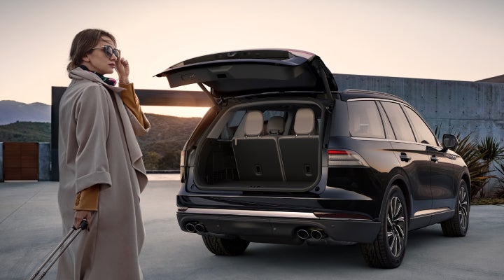 A woman approaches a 2026 Lincoln Aviator® SUV with its rear liftgate open. | Deacon Jones Lincoln in Goldsboro NC