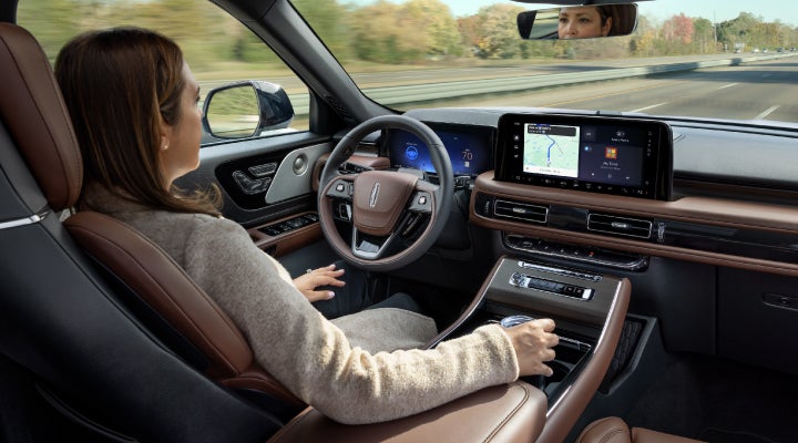 A 2026 Lincoln Aviator® SUV is being driven hands-free on a highway near a forest | Deacon Jones Lincoln in Goldsboro NC