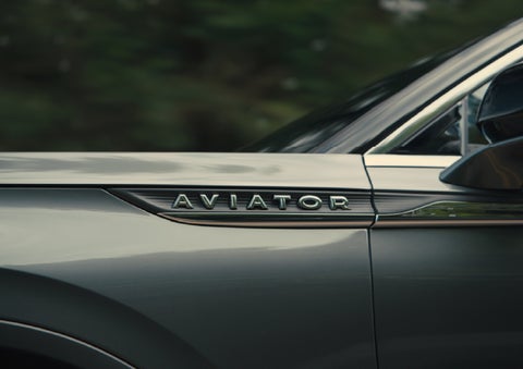 The driver’s side door and fender badging of a gray 2027 Lincoln Aviator® SUV are showcased. | Deacon Jones Lincoln in Goldsboro NC