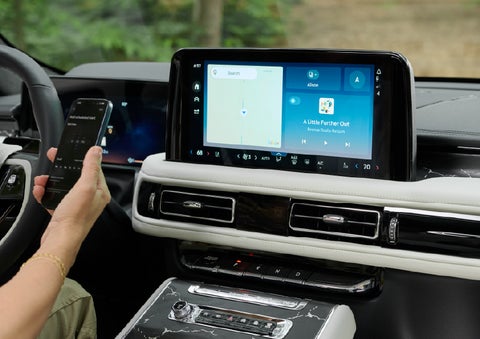 A person pairs thier phone with the center touchscreen of a 2027 Lincoln Aviator® Black Label™ SUV | Deacon Jones Lincoln in Goldsboro NC